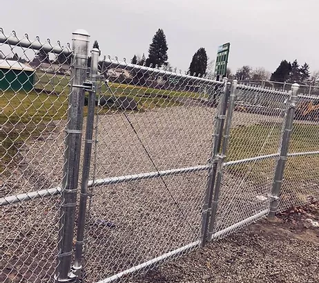 Silver chain link fence on baseball field with double gate