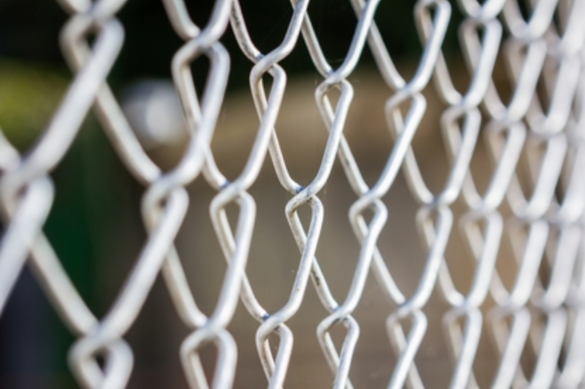 Close up photo of a new chain link fence galvanized style