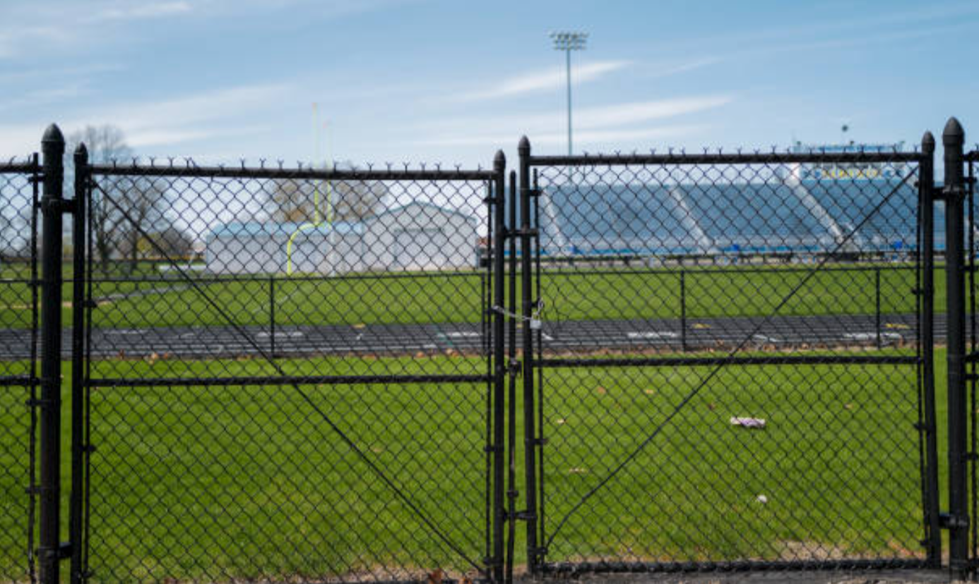 Unleveled black chain link gate that needs repair